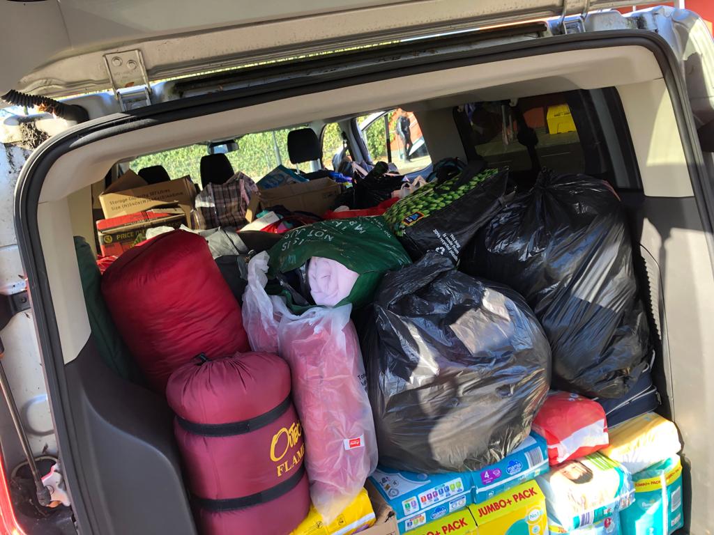 View of the rear door of a Minibus, pictured open and full of items to be donated for people affected by the Russia-Ukraine War.